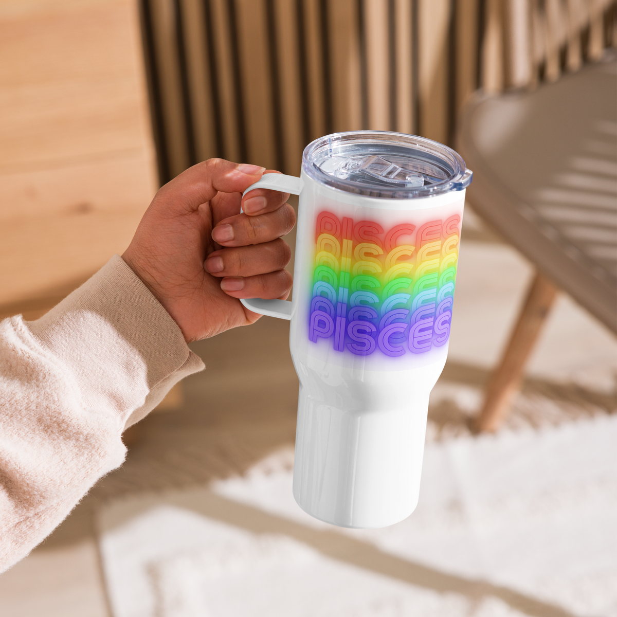 25oz. White tumbler with Pisces rainbow-colored text held by a hand in a casual setting
