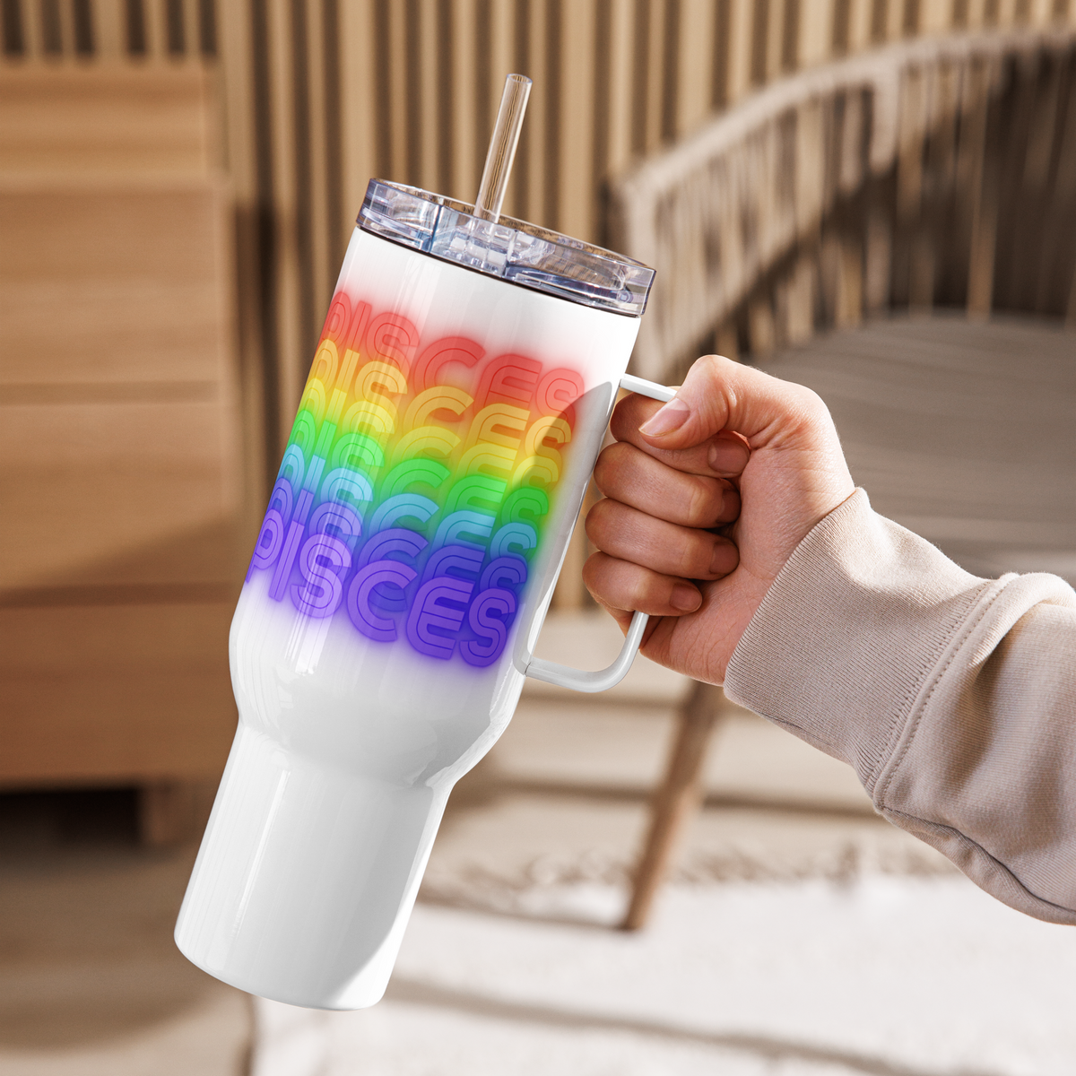 White tumbler with Pisces rainbow colored text held by a hand in a blurred indoor setting (40oz.)