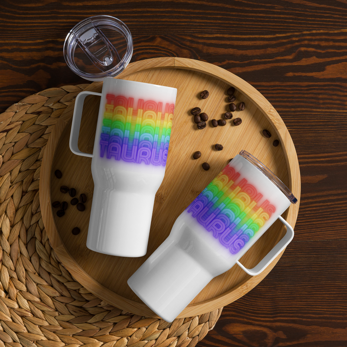 Two 25oz. white mugs with rainbow Taurus text design on a wooden tray with coffee beans.